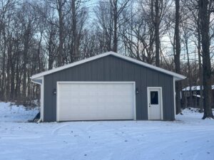 A newly installed white panel garage door on a modern grey building by McDonald Overhead Door Inc. in Kenosha, WI.