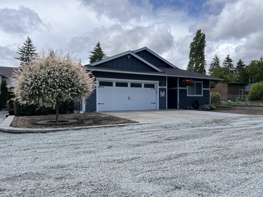 A white panel garage door installed on a residential home by Independent Garage Doors LLC in Tacoma, WA.