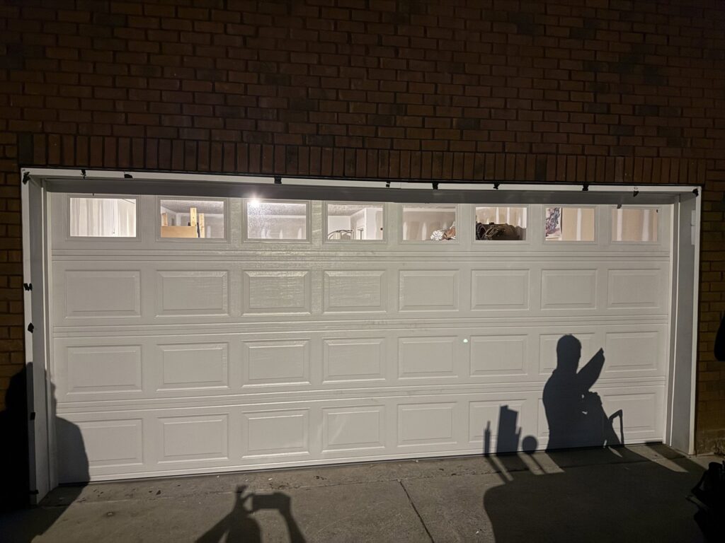 A white panel garage door with top row windows, newly installed by Swift Garage Door in Nashville, TN.