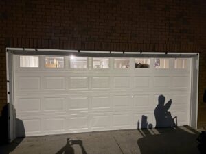 A white panel garage door with top row windows, newly installed by Swift Garage Door in Nashville, TN.