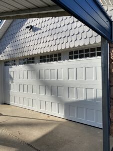 A newly installed white panel garage door with top windows on a home by Total Door Solutions in Yukon, OK