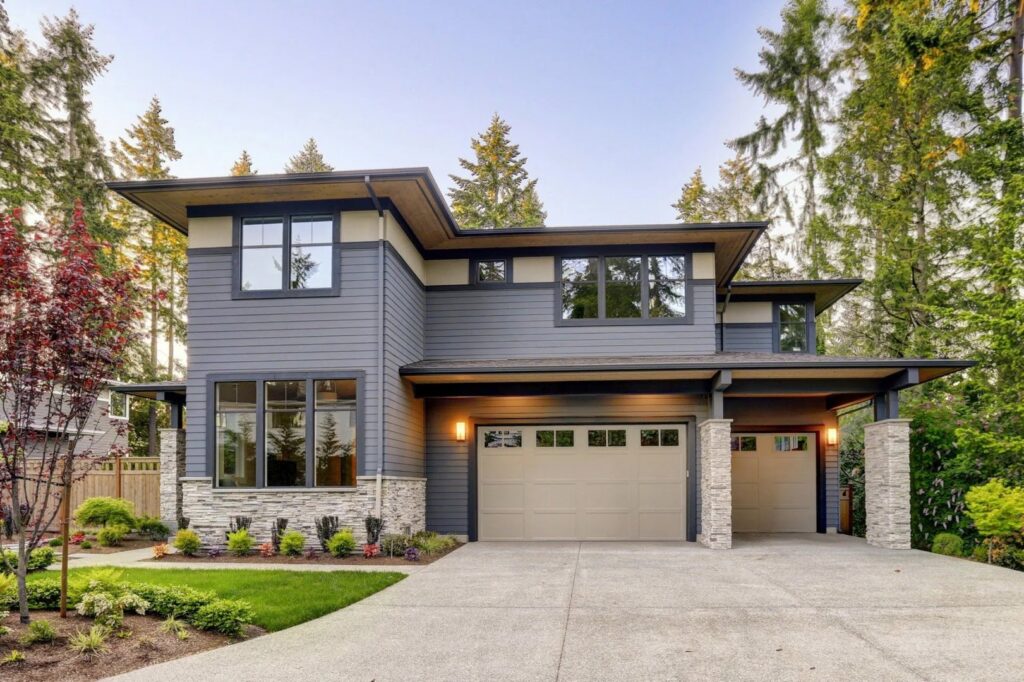 A classic white panel garage door with top windows on a house with a red roof, installed by Your Other Front Door LLC in Lakewood, CO.
