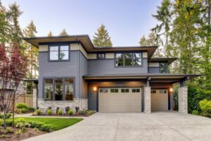 A classic white panel garage door with top windows on a house with a red roof, installed by Your Other Front Door LLC in Lakewood, CO.