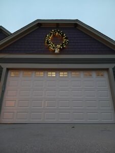 A white paneled garage door with top windows, showcasing a completed installation by Geiszler Garage Door in Milwaukee, WI.