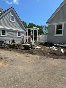 Installation of a white picket fence and matching arbor at a residential property by New England landscaping and fence inc in Lynn, MA.