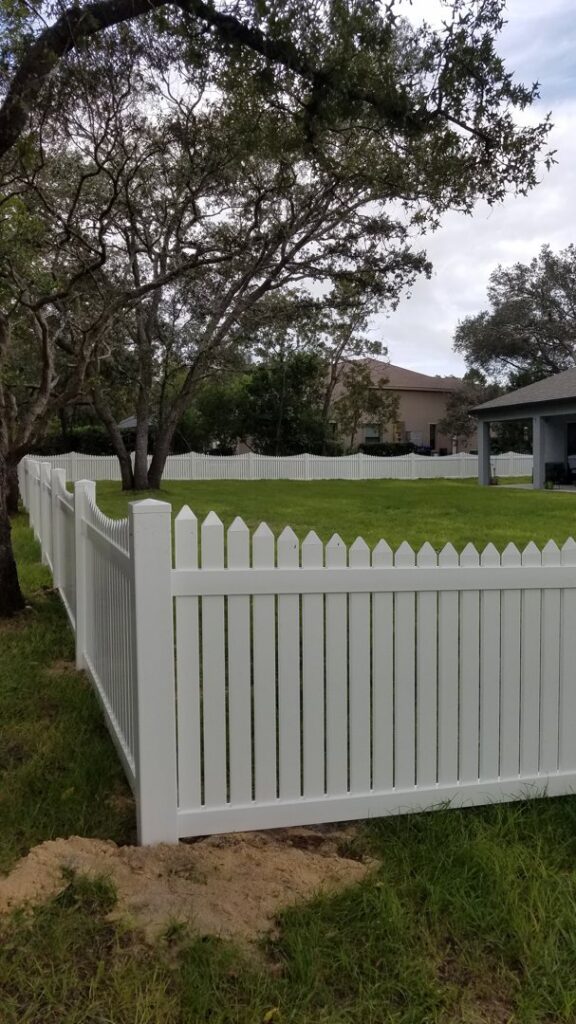 A classic white picket fence installed around a residential backyard by Aarons fence in Homosassa Springs, FL