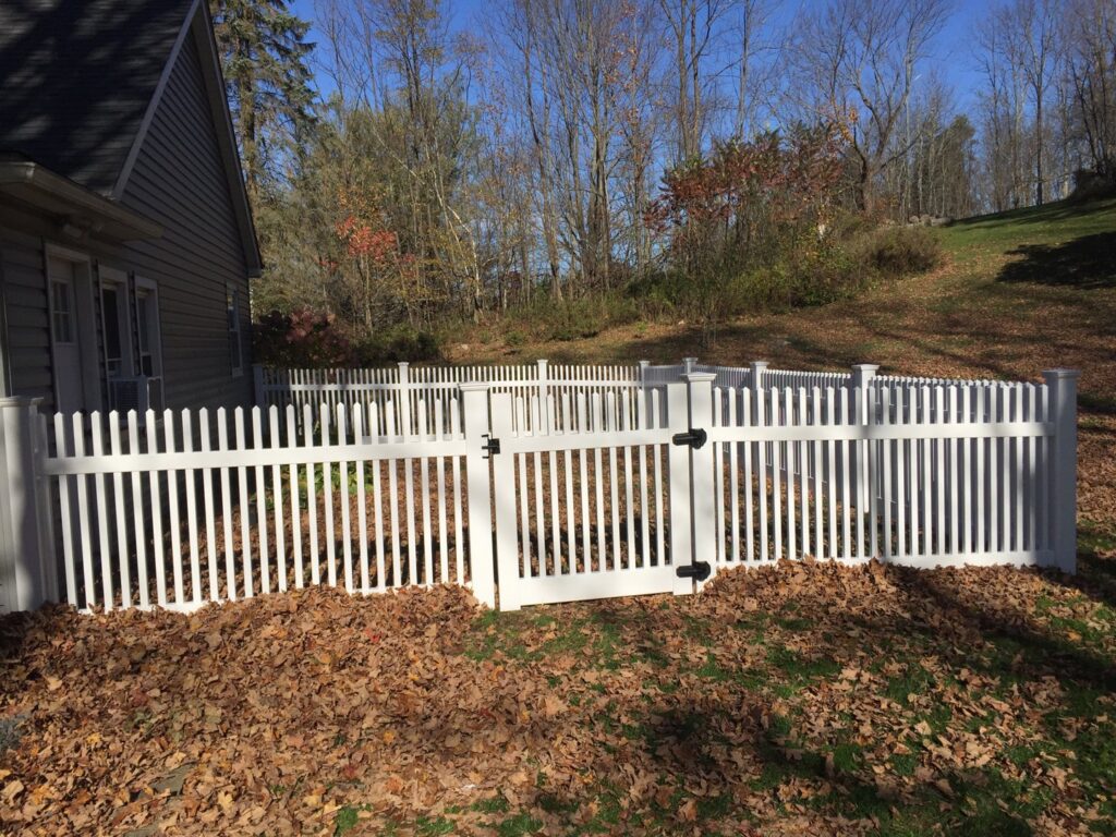 A classic white picket fence with a gate installed for a residential property by The Fence Dr. in Scranton, PA.