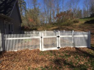 A classic white picket fence with a gate installed for a residential property by The Fence Dr. in Scranton, PA.