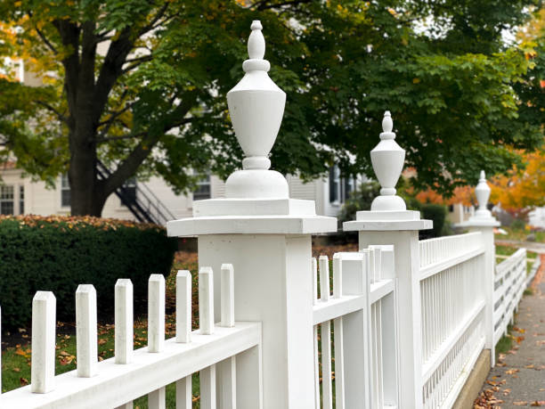 A beautiful white picket fence with decorative posts, showcasing quality fencing work by Delmarva Facility Maintenance Services in Laurel, DE.