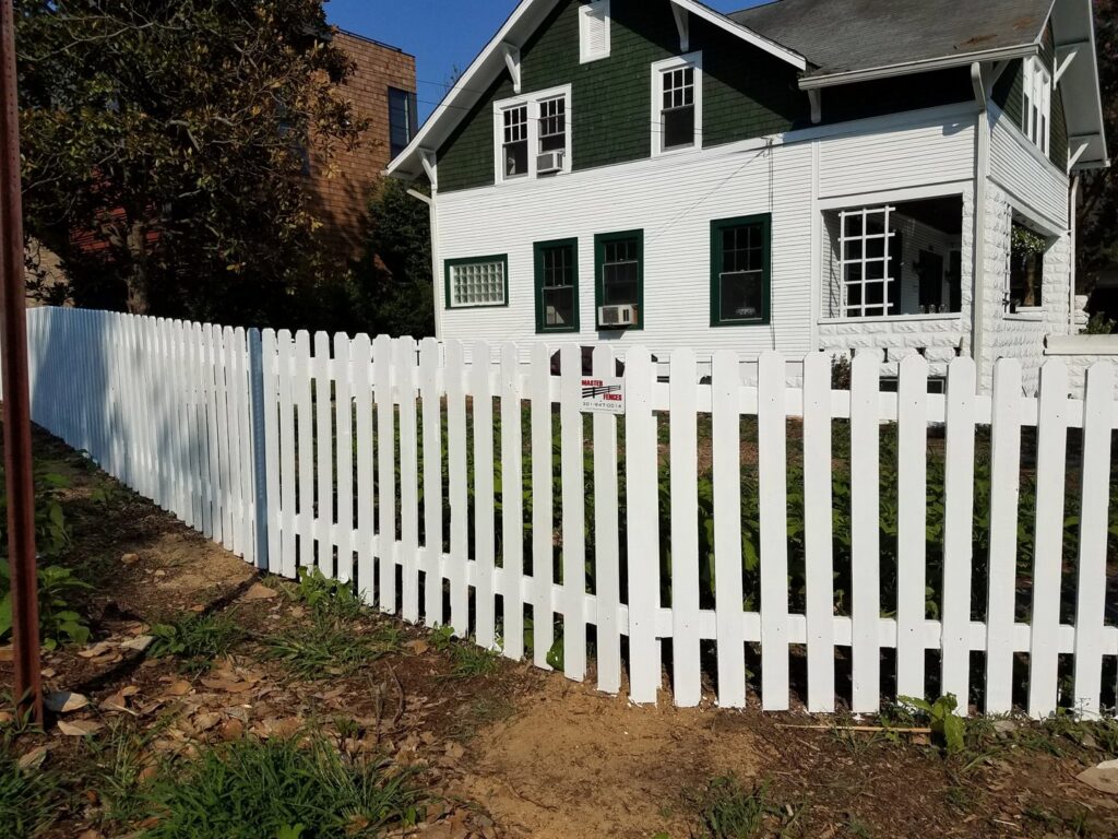 A classic white picket fence installed in front of a residential home by Master Fences in Gaithersburg, MD.