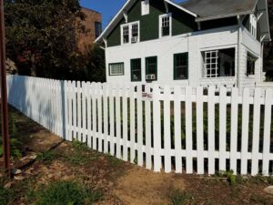 A classic white picket fence installed in front of a residential home by Master Fences in Gaithersburg, MD.