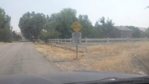 A classic white picket fence installed alongside a rural road by All Out Companies, LLC. in Fernley, NV.