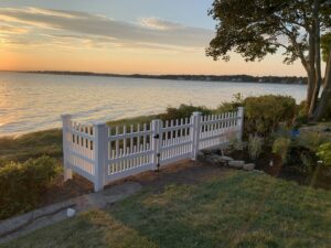 White picket fence with a gate overlooking the water, installed by Louis Fence installations & repairs in Fall River, MA
