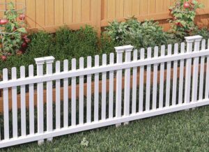 A classic white picket fence installed in a garden by Fence Company Chicago in Chicago, IL