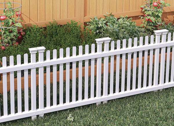 A classic white picket fence installed in a garden by Fence Company Chicago in Chicago, IL