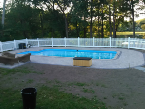 A white picket fence installed around a swimming pool for safety and aesthetics by Ocean State Fence Works LLC in North Kingstown, RI.