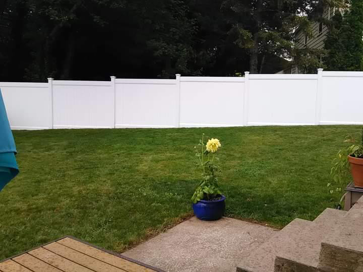 A clean white privacy fence installed in a residential backyard by Ocean State Fence Works LLC in North Kingstown, RI.
