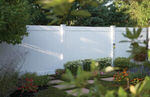 A white privacy fence installed in a beautifully landscaped garden by Fence Pros Direct in Saunderstown, RI.