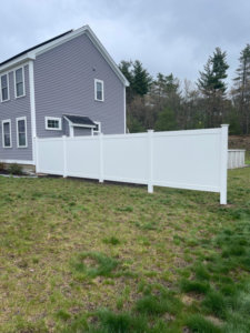 A sturdy white privacy vinyl fence installed along a residential property by Vinyl Fences Inc. in Dover, NH.