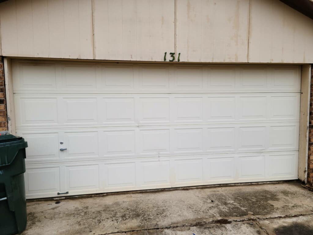 A white residential garage door installed on a brick house by Entry Garage Door in Shawnee, OK.