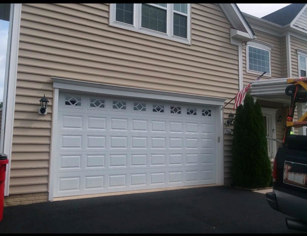 A newly installed white residential garage door with decorative windows by Midland Glass and Garage Doors in Frederick, MD