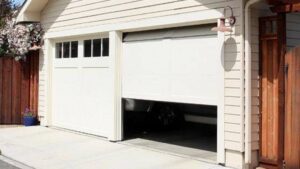 A white residential garage door partially open, showcasing a quality installation by Garage Doors Of Indianapolis in Indianapolis, IN
