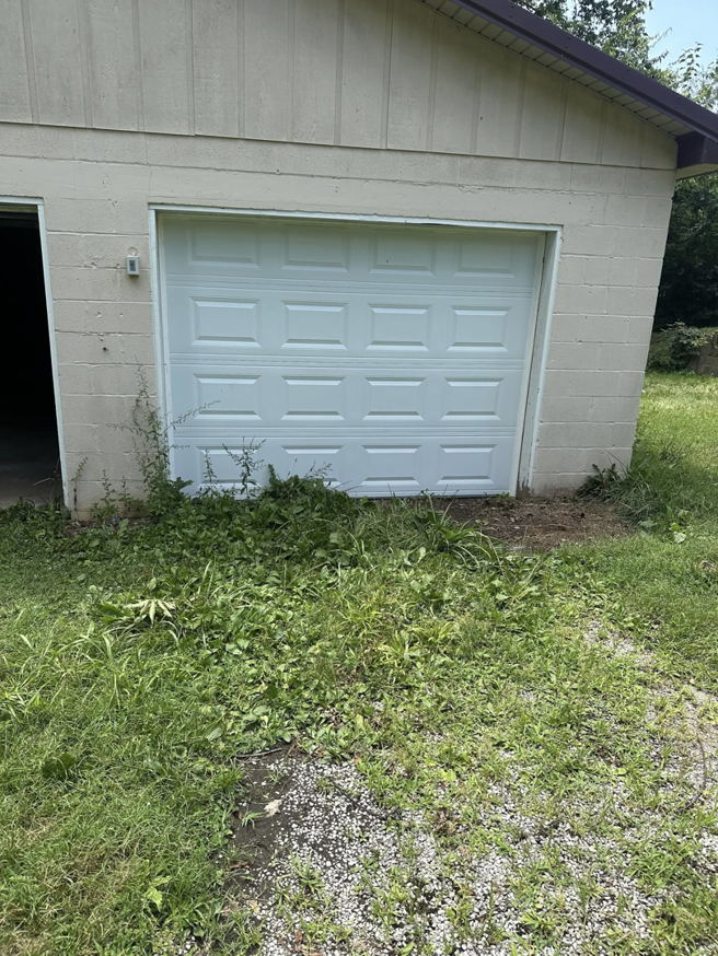 An exterior view of a white sectional garage door on a building by Phelps Dock and Door in Cave City, KY.