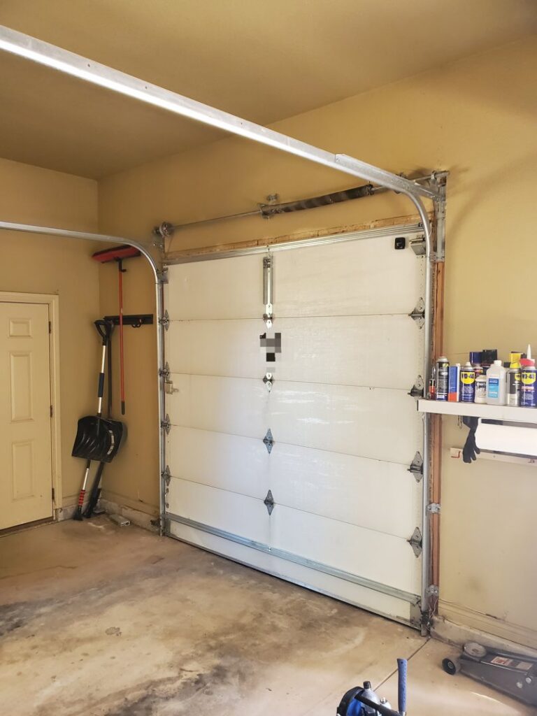 An interior view of a white sectional garage door, installed or serviced by Black Forest Door Repair in Colorado Springs, CO.