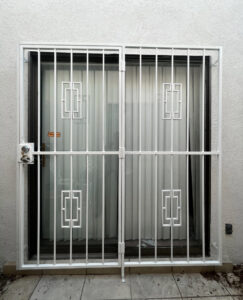 White security bars with geometric patterns installed on a sliding glass door by City Iron LLC in Albuquerque, NM.