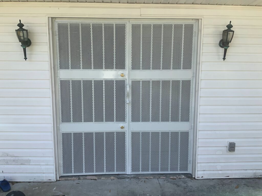 White security double doors with a mesh pattern installed by Ability Burglar Bars in Jacksonville, FL.