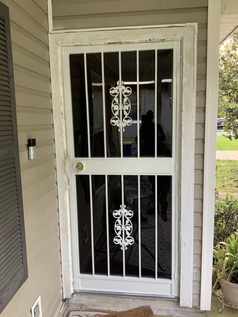 White security screen door with decorative scrollwork installed by Ability Burglar Bars in Jacksonville, FL.