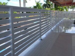 A white slatted balcony railing providing privacy and safety by Osuna Ornamental Fences & Gates in Cutler Bay, FL.