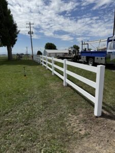 A new white split-rail style fence installed in a grassy field by All Over Fence Idaho in Jerome, ID