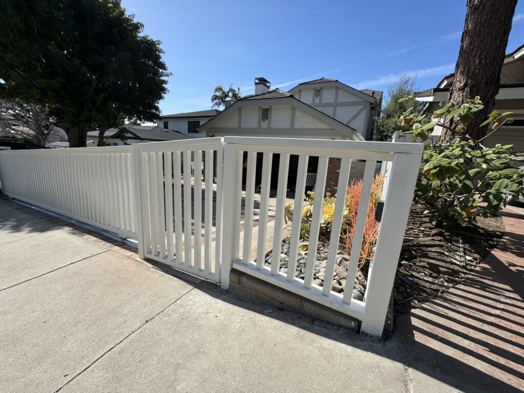 A clean white vertical slat fence and matching gate, installed by Harwell Fencing & Gates Inc. in Los Angeles, CA.