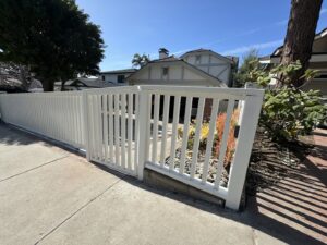 A clean white vertical slat fence and matching gate, installed by Harwell Fencing & Gates Inc. in Los Angeles, CA.