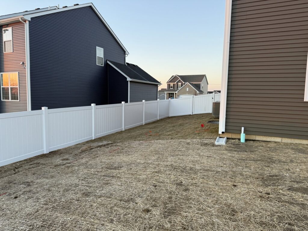 A white vinyl fence installed around a residential backyard by Fence Connection, Inc. in Elgin, IL.