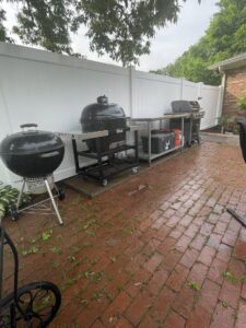 A white vinyl privacy fence installed in a backyard with a patio and grills by Pro Fence in Decatur, AL