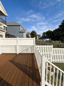 A white vinyl fence installed around a backyard deck by Heron Building Co in Franklin, TN.