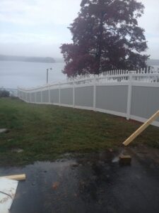 A white vinyl fence with a decorative top section installed along a waterfront by Timber Fencing in Charlotte, NC.