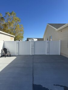 A white vinyl double gate installed on a concrete pad by 208 Fence and Gate in Idaho Falls, ID.