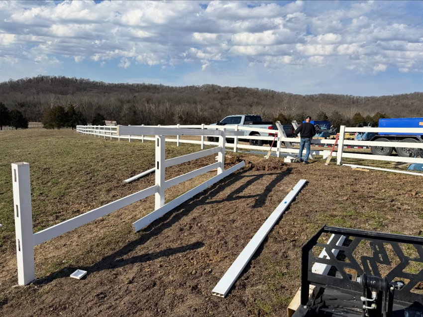 White vinyl farm fence installation in progress with materials and equipment by BK FenceWorks in Wentzville, MO.