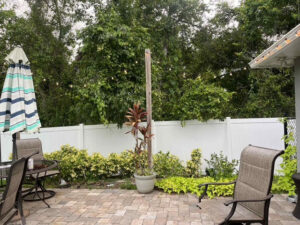 A white vinyl privacy fence enclosing a backyard patio area, installed by Native Outdoors, LLC in Orlando, FL.