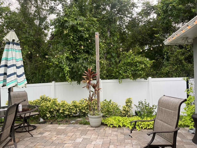 A white vinyl privacy fence enclosing a backyard patio area, installed by Native Outdoors, LLC in Orlando, FL.