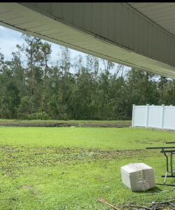A white vinyl fence installed in a spacious backyard with trees in the background by 5-Alarm Fence Company in New Orleans, LA.