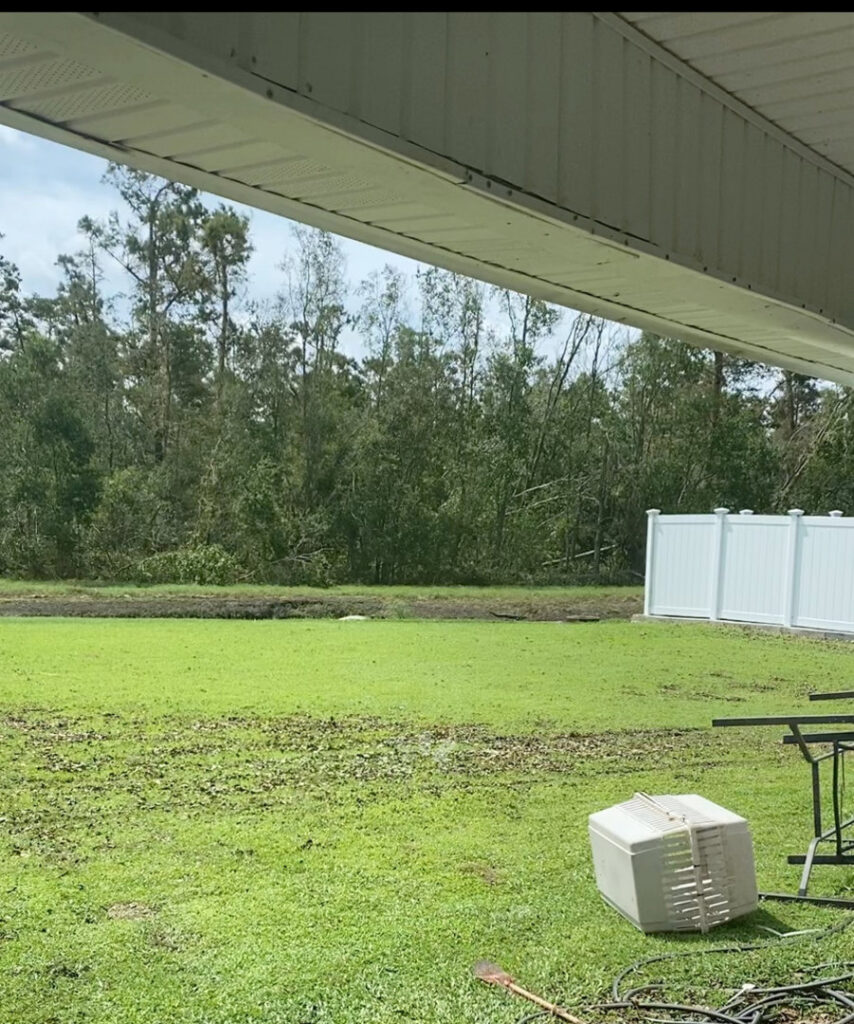 A white vinyl fence installed in a spacious backyard with trees in the background by 5-Alarm Fence Company in New Orleans, LA.