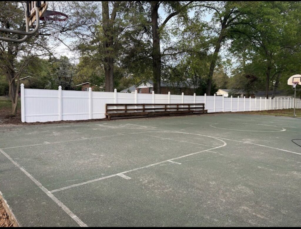 A white vinyl fence installed around a basketball court by CSRA Solutions in Jackson, SC.