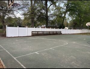 A white vinyl fence installed around a basketball court by CSRA Solutions in Jackson, SC.