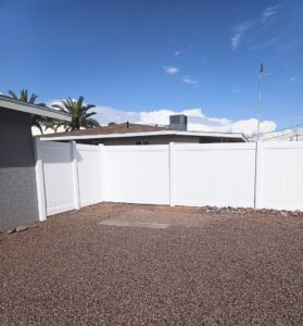 A white vinyl fence installed around a corner of a residential property by Competitive Fence Contractors LLC in Scottsdale, AZ.