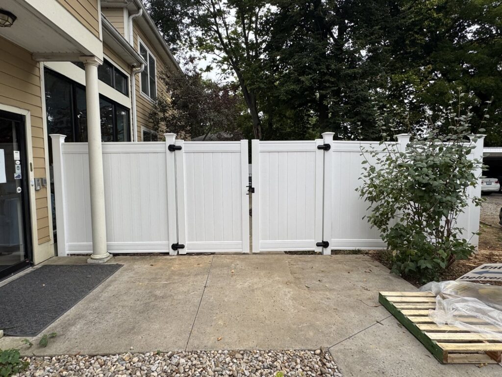 A white vinyl fence with a double gate installed by Shatkoff Fencing in Louisville, KY.