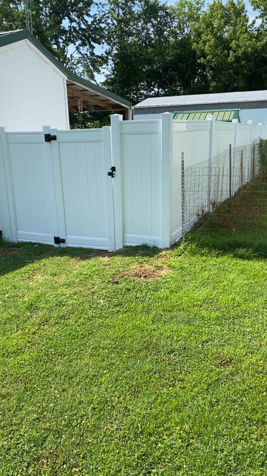 A new white vinyl fence with a gate installed by Higdon's fence install & repair in White Mills Junction, KY
